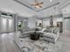 Spacious living room with gray sectional sofa, area rug, and view of kitchen and entryway at 82 Fairway Rd, Rotonda West, FL 33947