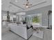 Open living room showcasing a gray sectional sofa, pool view, and access to the kitchen at 82 Fairway Rd, Rotonda West, FL 33947