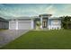 Two story house with attached two-car garage, light blue exterior and landscaping at 82 Fairway Rd, Rotonda West, FL 33947