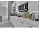 White kitchen cabinets and quartz countertops with a gray tile backsplash at 82 Fairway Rd, Rotonda West, FL 33947