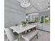 Modern dining area featuring a marble table, gray bench, and view into the kitchen and living areas at 82 Fairway Rd, Rotonda West, FL 33947