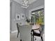 Casual dining area with a round table and four gray chairs, leading to a screened patio at 82 Fairway Rd, Rotonda West, FL 33947
