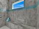 Walk-in shower with gray tile, stone bench, and blue mosaic accents at 6 Fairway Rd, Rotonda West, FL 33947