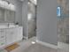 Bathroom features a white vanity, walk-in shower, and gray tile at 6 Fairway Rd, Rotonda West, FL 33947