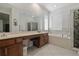 Bathroom with double vanity, soaking tub, and stained glass shower door at 8231 Dunham Station Dr, Tampa, FL 33647