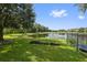 Large backyard with pond view, lush lawn, and mature trees at 8231 Dunham Station Dr, Tampa, FL 33647