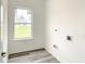 Laundry room with vinyl flooring and a window for natural light at 2165 Music Ln, North Port, FL 34286