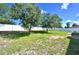 Large backyard with grassy area, mature trees, and a white vinyl fence at 10255 Norwick St, Spring Hill, FL 34608