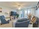 Living room with balcony access, comfortable seating, and large TV at 25188 Marion Ave # A103, Punta Gorda, FL 33950