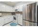 Efficient kitchen with white cabinets, stainless steel appliances, and mosaic backsplash at 25188 Marion Ave # A103, Punta Gorda, FL 33950