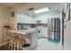 Open kitchen with breakfast bar, white cabinets, and stainless steel appliances at 25188 Marion Ave # A103, Punta Gorda, FL 33950