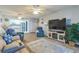 Open concept living room and kitchen, featuring comfortable seating and a large TV at 25188 Marion Ave # A103, Punta Gorda, FL 33950