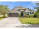 One-story home with a two-car garage and well-manicured lawn at 8064 Olive Brook Dr, Wesley Chapel, FL 33545