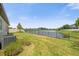 Grass backyard next to a pond with a fence at 8064 Olive Brook Dr, Wesley Chapel, FL 33545