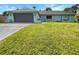 Newly renovated home with gray garage door and green lawn at 3451 Sage St, Port Charlotte, FL 33948