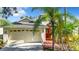 One-story home with a red door, attached garage, and palm trees at 423 Durham Shore Ct, Apollo Beach, FL 33572
