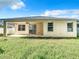 Tan house exterior with covered patio and grassy backyard at 423 Durham Shore Ct, Apollo Beach, FL 33572