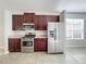 Kitchen with stainless steel appliances and dark wood cabinets at 423 Durham Shore Ct, Apollo Beach, FL 33572