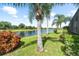 Waterfront backyard with lush landscaping and palm trees at 12515 23Rd E St, Parrish, FL 34219