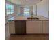 Stylish kitchen with an island, stainless steel dishwasher, and open layout to the dining area at 9613 Vibrant Lane, Venice, FL 34292