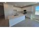 Bright kitchen featuring white cabinets, stainless steel appliances, and a center island at 9613 Vibrant Lane, Venice, FL 34292