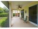 Relaxing screened porch with seating area, ceiling fan, and view of backyard at 4450 Golden Lake Dr, Sarasota, FL 34233