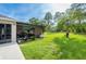 Large backyard with grassy area and screened porch at 18405 Waydale Loop, Hudson, FL 34667