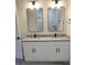 Bathroom vanity features double sinks, granite countertop, modern lighting, and stylish mirrors at 7137 Benson St, Englewood, FL 34224