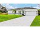 Charming single story home with an attached garage, paved driveway, and manicured lawn at 7137 Benson St, Englewood, FL 34224