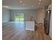 Open concept kitchen with island, stainless steel appliances, and grey vinyl flooring at 7137 Benson St, Englewood, FL 34224