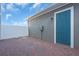 Cozy outdoor brick patio with blue back door and white fence, perfect for relaxation and entertainment at 17314 Alderwood Ln, Punta Gorda, FL 33982