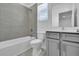 Bathroom featuring a tub, shower, toilet, and vanity with gray cabinets at 17314 Alderwood Ln, Punta Gorda, FL 33982