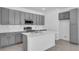 Modern kitchen with gray cabinets, stainless steel appliances, a stylish island, and a subway tile backsplash at 17314 Alderwood Ln, Punta Gorda, FL 33982