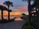 Scenic waterfront walkway at sunset with palm trees at 17314 Alderwood Ln, Punta Gorda, FL 33982