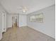 Well-lit bedroom featuring tile flooring and access to hallway at 11805 Carmen Ave, Dade City, FL 33525