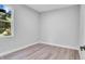 Bright bedroom with wood-look floors and a window at 1117 Vernon Ave, Port Charlotte, FL 33948