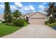 Tan house with a three-car garage and well-manicured landscaping at 6043 Anvil Ave, Sarasota, FL 34243