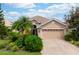 Tan house with a three-car garage and lush landscaping at 6043 Anvil Ave, Sarasota, FL 34243