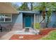 Inviting home exterior with teal front door and landscaping at 7329 Royal Palm Dr, New Port Richey, FL 34652