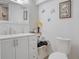 Clean bathroom with double vanity, toilet and decorative accents at 7329 Royal Palm Dr, New Port Richey, FL 34652