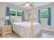 Bright bedroom featuring a post bed and wood flooring at 7329 Royal Palm Dr, New Port Richey, FL 34652
