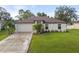 Single-story house with a two-car garage and well-maintained lawn at 1276 Banter Cir, North Port, FL 34288