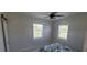 Bright bedroom with two windows, ceiling fan and bed featuring a tropical pattern bedspread at 3420 Ash St, Punta Gorda, FL 33950