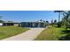 Quaint blue home with a gravel driveway and a well-manicured lawn at 3420 Ash St, Punta Gorda, FL 33950