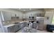 Modern kitchen featuring gray cabinets, stainless steel appliances, and a glass dining table at 3420 Ash St, Punta Gorda, FL 33950