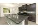 Modern kitchen features a large granite island, stainless steel appliances, and beautiful dark brown cabinets at 31510 Tansy Bnd, Wesley Chapel, FL 33545