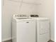 This laundry room features a Maytag washing machine, dryer, and wire shelving for storage at 31510 Tansy Bnd, Wesley Chapel, FL 33545
