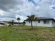 Side view of a white brick home with a black metal roof at 1359 Cambridge Dr, Venice, FL 34293