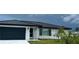White brick home with a black metal roof and garage at 1359 Cambridge Dr, Venice, FL 34293