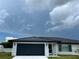 White brick home with a black metal roof and garage at 1359 Cambridge Dr, Venice, FL 34293
